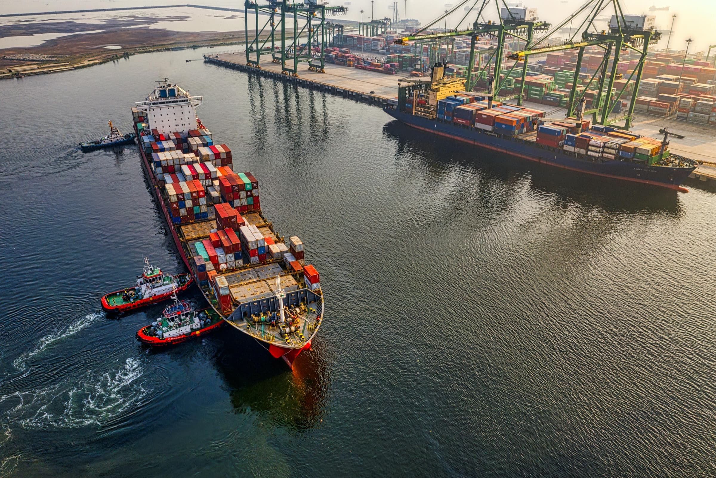 Navă portcontainer manevrată de remorchere la intrarea în terminalul portuar.